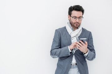 businessman with scarf on neck typing SMS on smartphone.