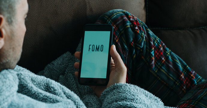 man reads text fomo in his smartphone, web banner