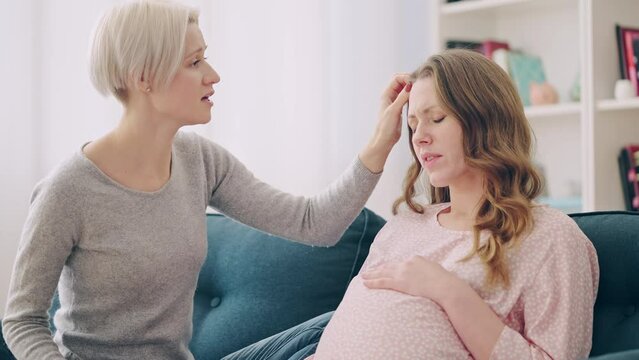 Pregnant woman complaining about feeling unwell and swellings to her friend