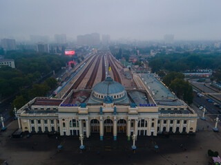 The main railway station of Odessa from a height on a foggy day. Located in the city center, in the Primorsky district. The Ukrainian flag flies over the building.
