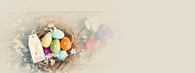 Easter greeting card with text in German - Frohe Ostern - Easter nest with colorful eggs	