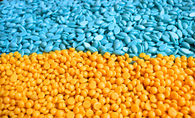 hard wax beans in perspective with different formats and the colors of the Ukrainian flag in yellow and blue - closeup in perspective
