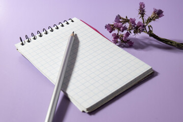 Notepad, pencil and flowers on a light  background. concept idea