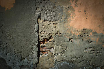 Dark background. Detail of an old plastered brick wall.