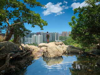 man in front of a reflected lake, countryside of Sai Kung with buildings, Hong Kong, outdoor
