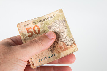 Brazilian money. Hand holding 50 reais banknotes. Brazilian finance concept.