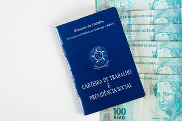 Fototapeta premium Brazilian document work and social security (Carteira de Trabalho e Previdencia Social) with Brazilian money banknotes