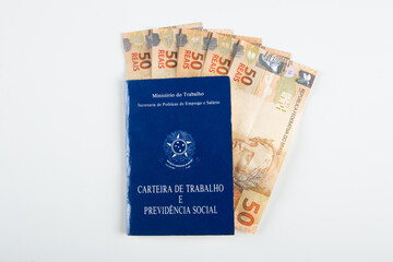 Brazilian document work and social security (Carteira de Trabalho e Previdencia Social) with Brazilian money banknotes