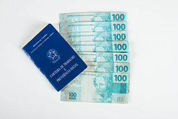 Brazilian document work and social security (Carteira de Trabalho e Previdencia Social) with Brazilian money banknotes