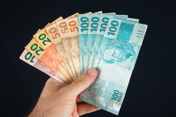 Hand holding Brazilian money banknotes. Brazilian finance concept
