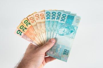 Hand holding Brazilian money banknotes. Brazilian finance concept