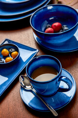 Obraz na płótnie Canvas Coffee and fruit in blue cutlery