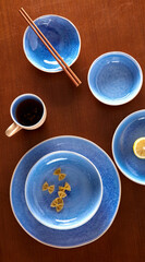 Blue cutlery with raw bow noodles and lemon