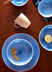 Blue cutlery with raw bow noodles and lemon