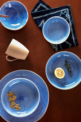 Obraz na płótnie Canvas Blue cutlery with raw bow noodles and lemon