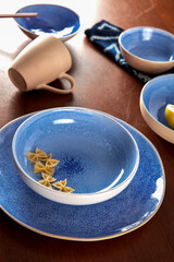 Blue cutlery with raw bow noodles and lemon