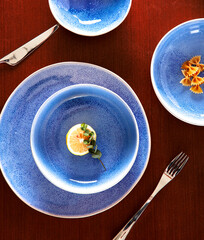 Blue cutlery with raw bow noodles and lemon