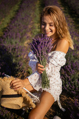 Young pretty blonde woman in lavender field on sunny summer day
