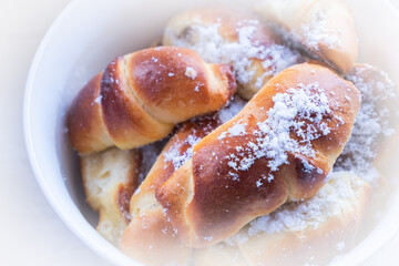 sweet buns with powdered sugar plate close-up
