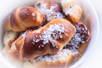 sweet buns with powdered sugar plate close-up