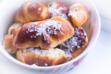 sweet buns with powdered sugar plate close-up
