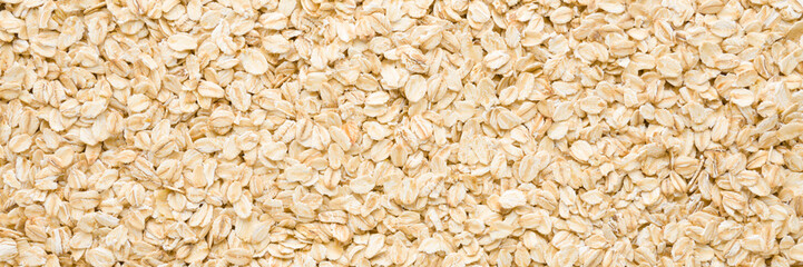 Dry rolled oat background. Wide banner. Closeup. Healthy food. Top down view.