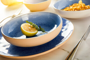 Blue cutlery with raw bow noodles and lemon