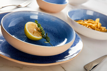 Blue cutlery with raw bow noodles and lemon