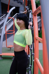 Fitness sport girl in fashion sportswear doing yoga fitness exercise on sport trendy playground on the street, outdoor sports, urban style