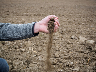 Ein Bauer prüft die Erde auf Trockenheit mit seiner Hand. Dürre, Klima.