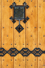 Wooden entrance door with wrought iron elements.