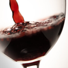 Red vine being pouring into a glass closeup vine splashing splash