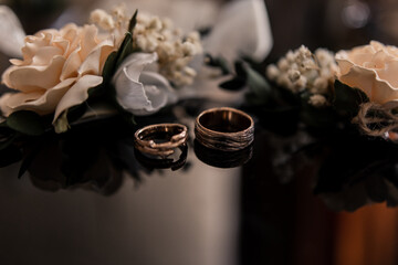 beautiful wedding rings with flowers on the ceremony table