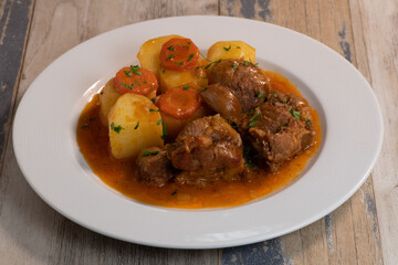 Navarin Lamb Shank Stew on wood table and and potatoes
