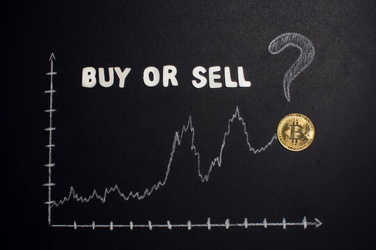 Bitcoin graphic with arrow up and text " Buy or sell" with question mark on blackboard as cryptocurrency online trade value growing concept.