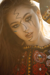 Fototapeta premium Close-up of a Ukrainian girl with tears in her eyes, wearing national clothes, a sad expression.