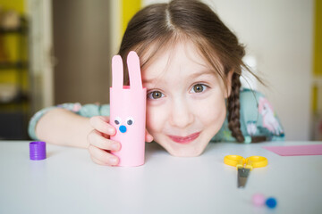 easter paper craft for kids. child girl making banny in kindergarten in spring