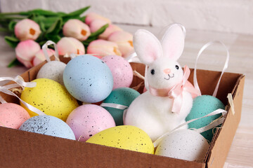 A set of decorative Easter eggs in a box with a cute rabbit.