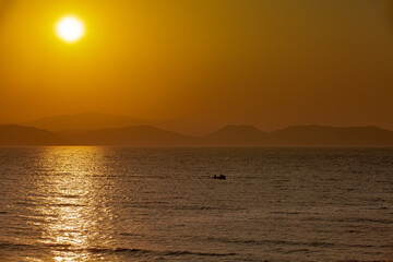 Gold time of the day on a beach in Turkey, near Kusadasi with vessel in horizon