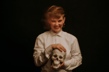 psychopath with schizophrenia and mental disorders. Portrait of a girl with a skull in hands on a...