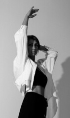A slender woman with outstretched arm up and another arm behind the head