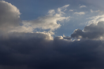 beautiful spring sky, covered with big clouds. extremely amazing, dramatic and apocalyptic sky and the sun and sunny rays. the sun is shining through dark clouds. sunshine. sunset