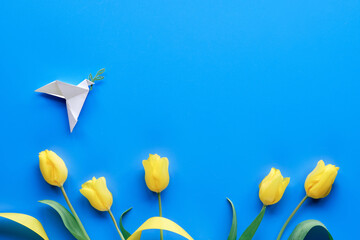 Dove of peace, paper origami. Peace to Ukraine. Yellow tulips, flowers, on blue background....