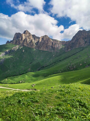 Naklejka na ściany i meble The landscape of the green Aktoprak pass in the Caucasus, the road and the mountains under gray clouds. Russia.