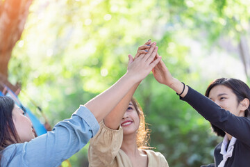 Obraz premium Group girls hands together giving high five feels excited close up focus on stacked palms. celebration and friendship concept