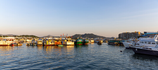 Fototapeta premium various Junks park at harbor in Sai Kung, Hong Kong, a typhoon shelter, where junks used in the local tourist trade now are moored. also famous for sea food