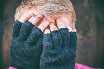 Mann schlägt die Hände vor dem Gesicht zusammen als Zeichen für Scham, Hilflosigkeit oder Trauer