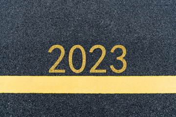 Number 2023 and yellow line on asphalt road