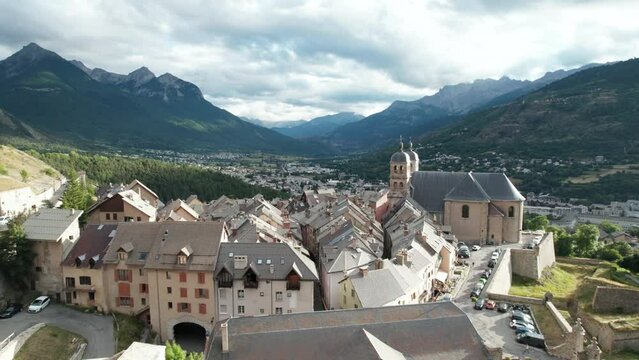Old village with church at top of forested hill. Aerial shot flying low on the buildings of Briancon, one of France historical towns, in autumn