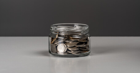 Coins in glass jar. currency money on dark gray background for business and finance concept